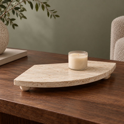 Footed Travertine Fan Tray on a coffee table with a candle